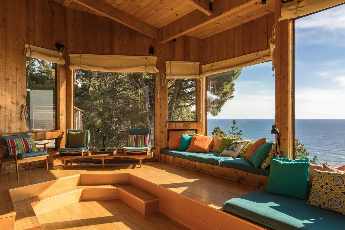Wood-paneled sunroom with built-in window seats overlooking the water