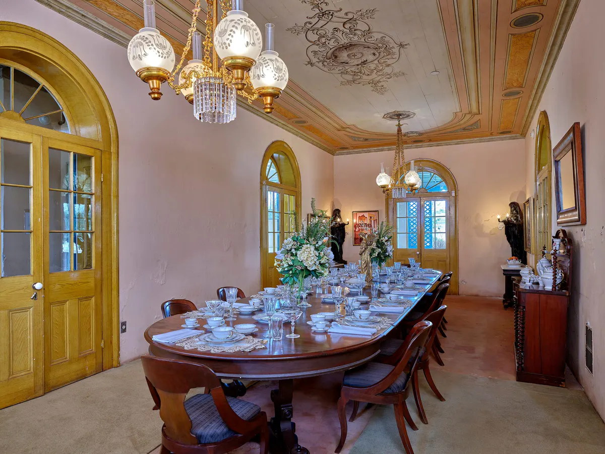 Formal dining room with portraits and chandelier